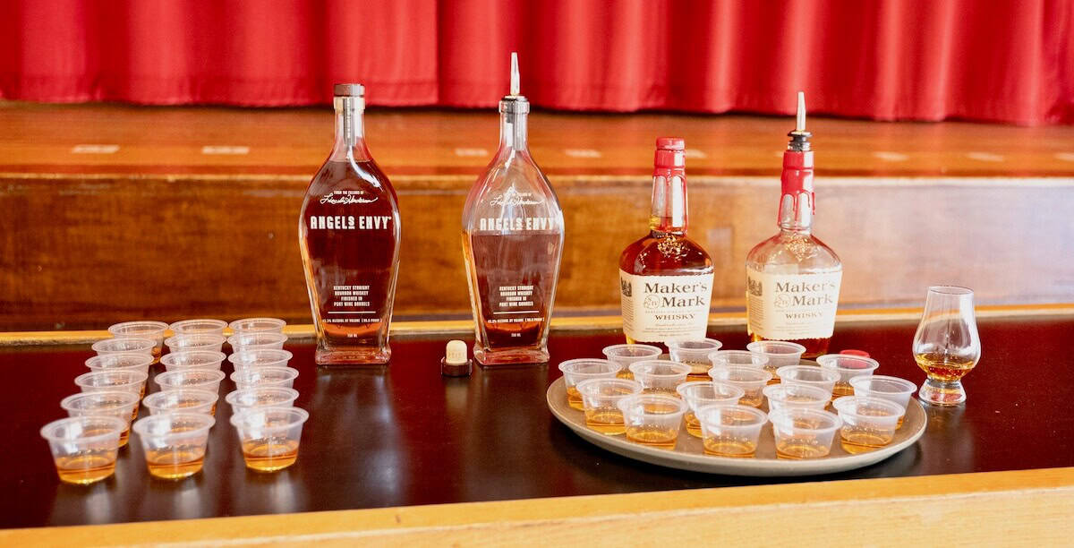 Angels Envy and Marker's Mark bourbons in bottles and portioned into tasting glasses.