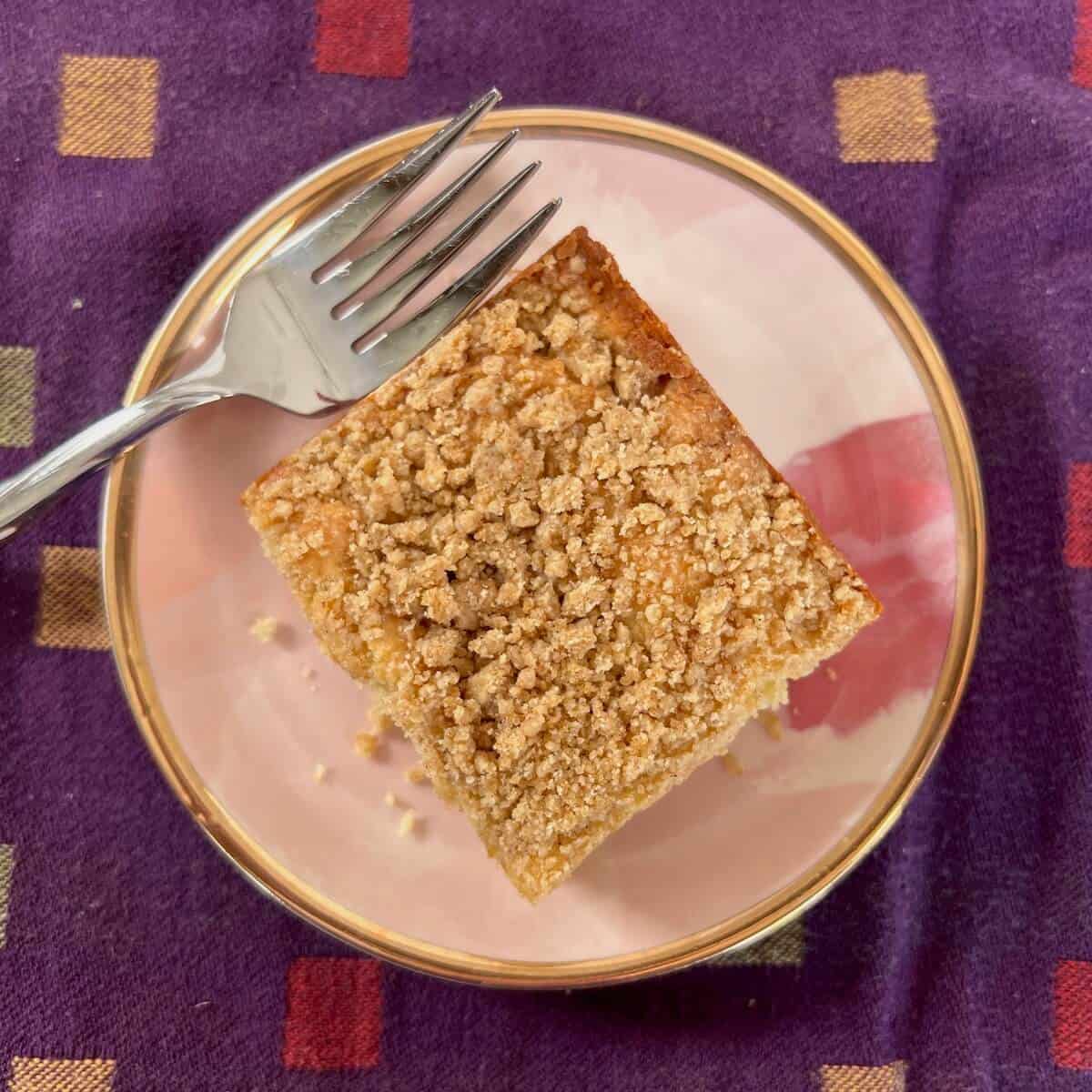 Sourdough Discard Tahini Coffee Cake and a fork on a pink plate from overhead.