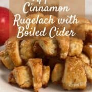 Apple Cinnamon Rugelach stacked on a white plate in front of an apple and a jar of boiled cider Pinterest banner.