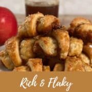 Apple Cinnamon Rugelach stacked on a white plate in front of an apple and a jar of boiled cider Pinterest banner.